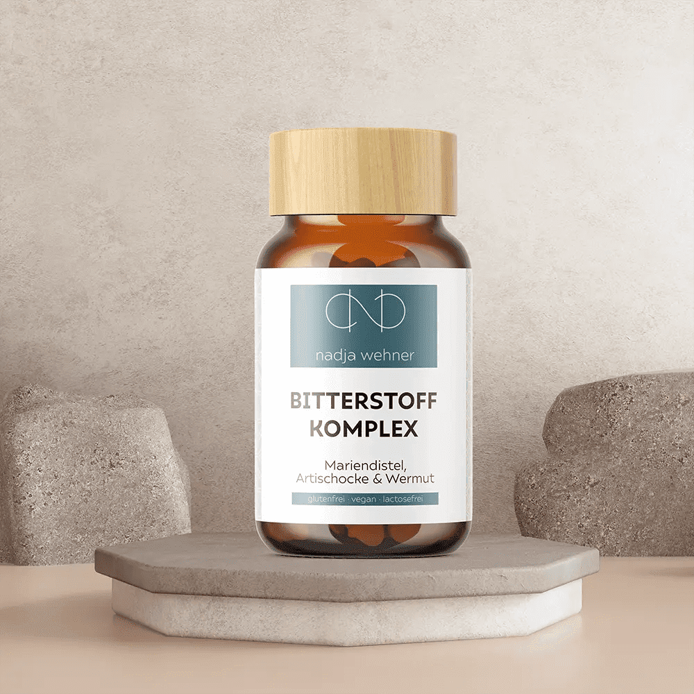 Eine Bitterstoff Komplex-Flasche der Rosen Apotheke Manufaktur mit einem Verschluss mit Holzstruktur steht auf einer Steinplattform inmitten von Steinformen und hebt die natürliche Mischung mit der starken Kraft von Kurkuma hervor.